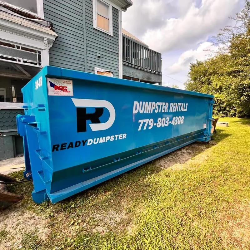 Blue Ready Dumpster container beside a house