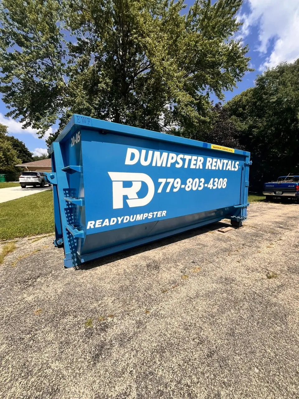 Blue Ready Dumpster container beside a driveway